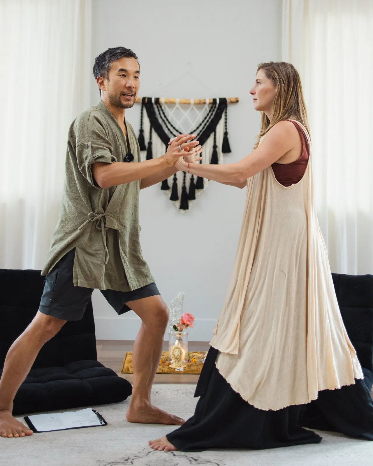 Edmond and Kiki standing face to face, arms clasped in the dyad practice